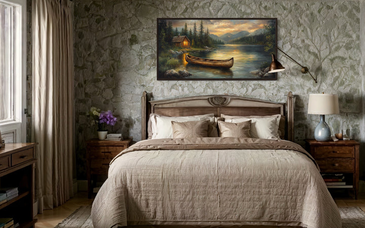 Rustic canvas wall art of a wooden canoe on a serene lake with a cabin and mountains at sunset.