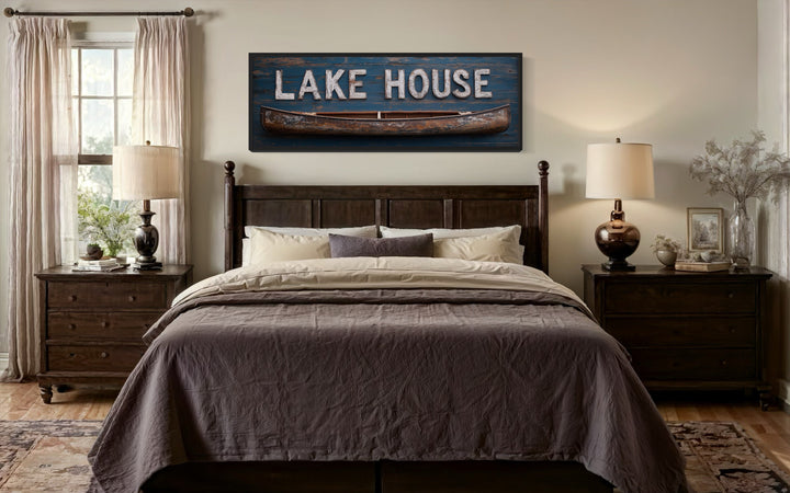 Lake House Sign With Wooden Canoe Long Horizontal Framed Canvas Wall Art above a bed.