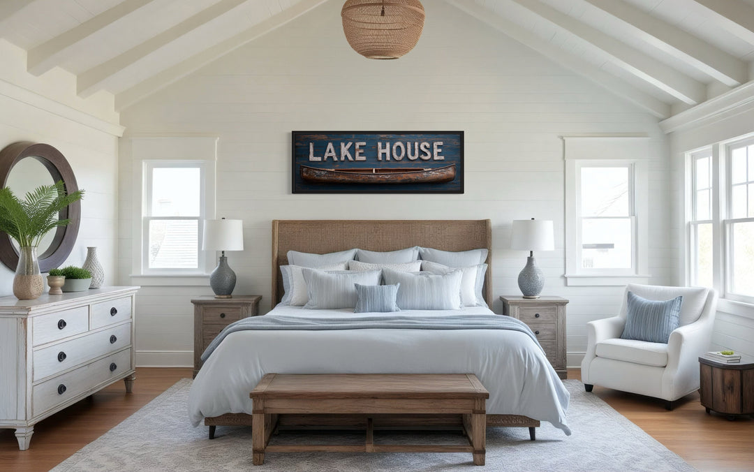 Lake House sign with wooden canoe framed canvas wall art hanging above a bed in a rustic bedroom.