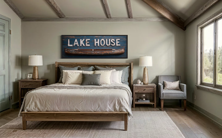 Lake House sign with wooden canoe long horizontal framed canvas wall art above a bed.