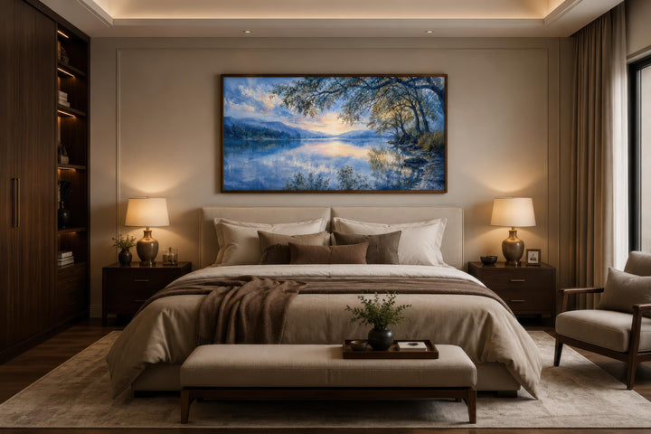 Blue lake painting framed canvas print hanging above a bed in a modern, neutral-toned bedroom.