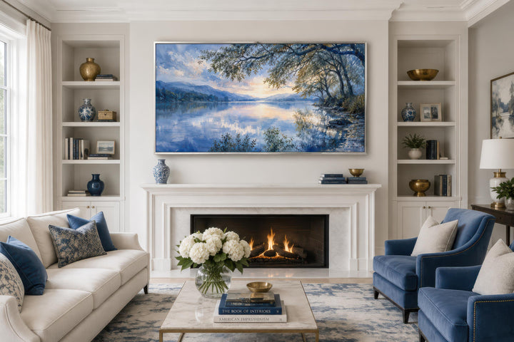 Framed blue lake landscape painting on canvas hanging above a white fireplace in a living room.