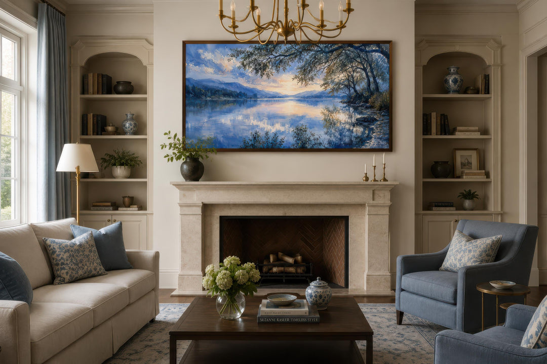 Framed horizontal blue lake landscape painting hanging above a fireplace in a classic living room.