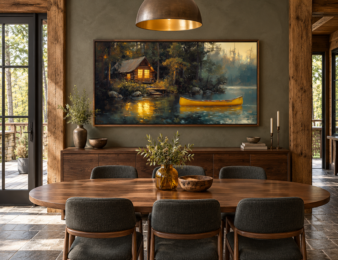 Framed canvas art of a rustic lake house and yellow canoe hanging in a modern cabin dining room.