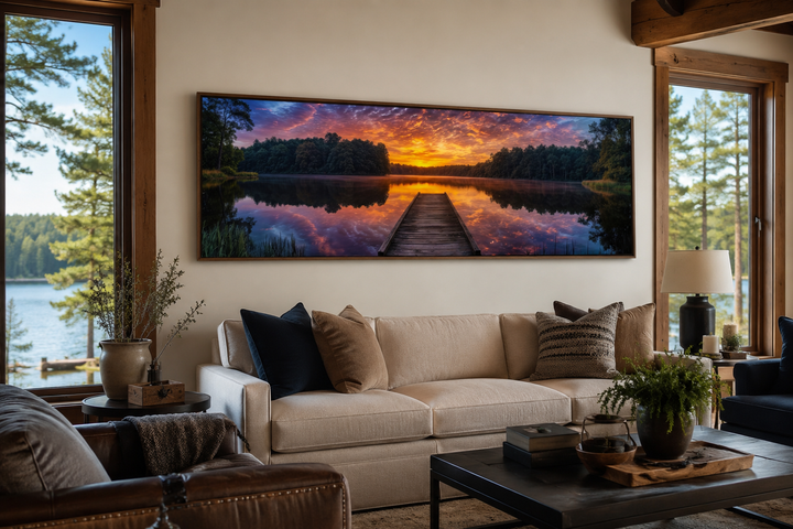 Horizontal canvas wall art of a lake landscape with a wooden fishing pier at sunset over a sofa.