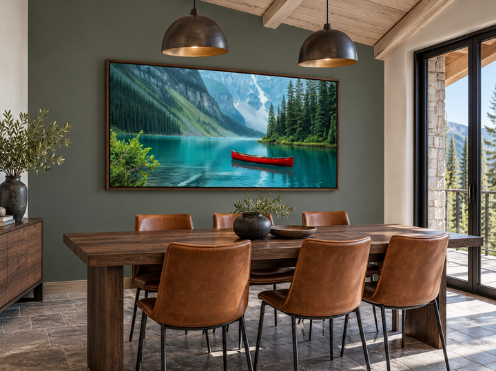 Framed canvas wall art of Lake Louise with a red canoe in a rustic dining room.