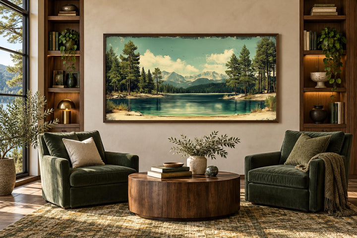 Vintage style canvas wall art of a calm lake, pine forest, and mountains in a walnut frame.
