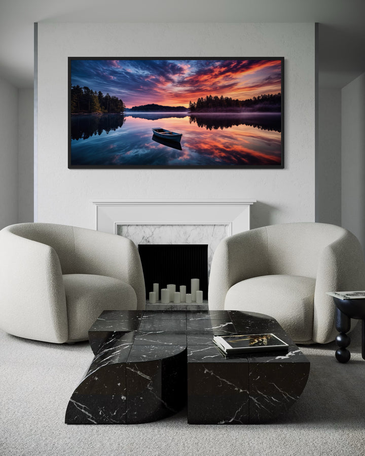 Framed canvas print of a boat on a serene lake at sunset, hanging above a white fireplace.