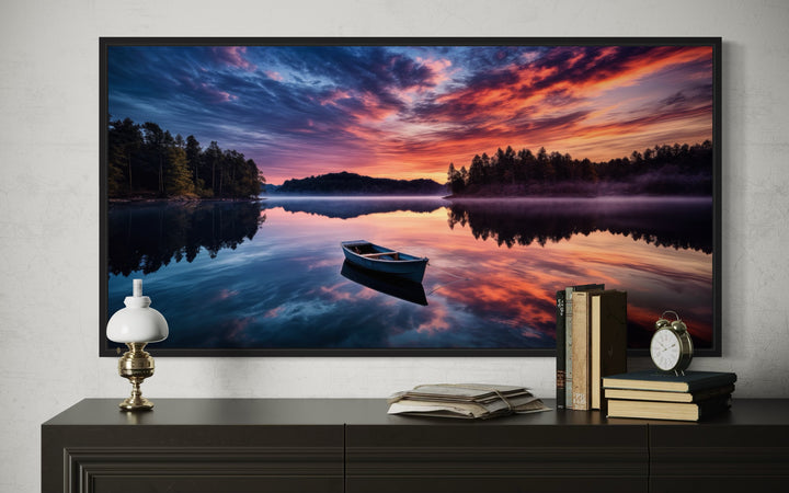 Framed canvas print of a boat on a calm lake at sunset, displayed above a dark wooden console table.