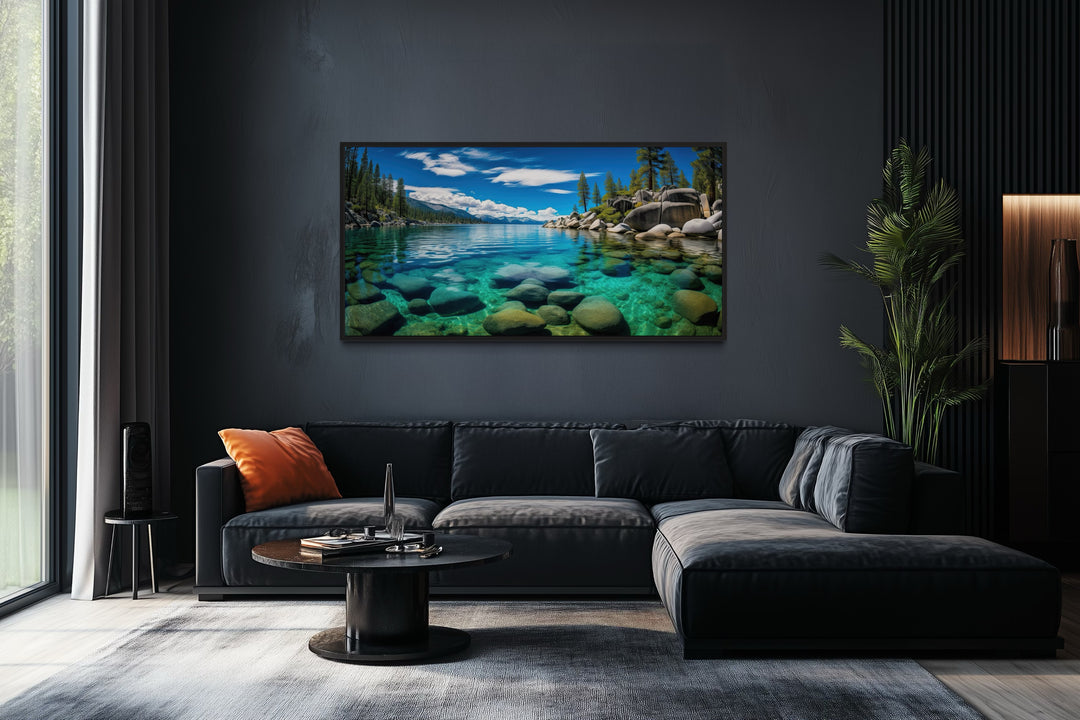 Framed canvas print of Sand Harbor, Lake Tahoe, hanging above a modern black sectional sofa.
