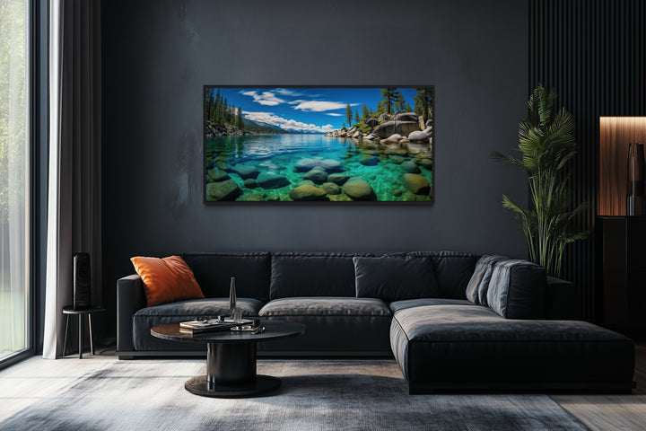 Framed canvas print of Sand Harbor, Lake Tahoe, hanging above a modern black sectional sofa.