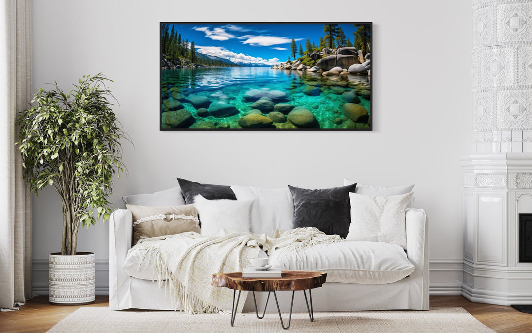 Framed Lake Tahoe wall art featuring Sand Harbor's clear blue water and rocks above a white sofa.