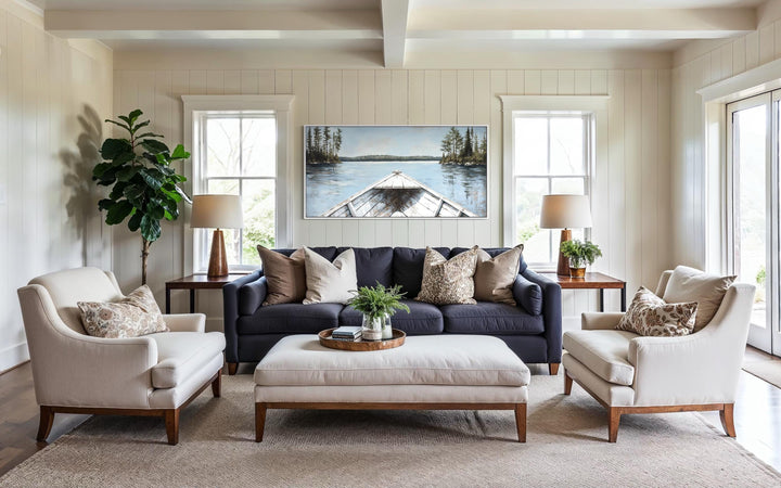 Lake View wall art featuring a white canoe on a blue lake, hung above a sofa in a living room.