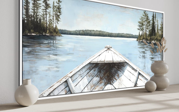 Lake View wall art featuring a white canoe on a blue lake with evergreen trees and a pale sky.
