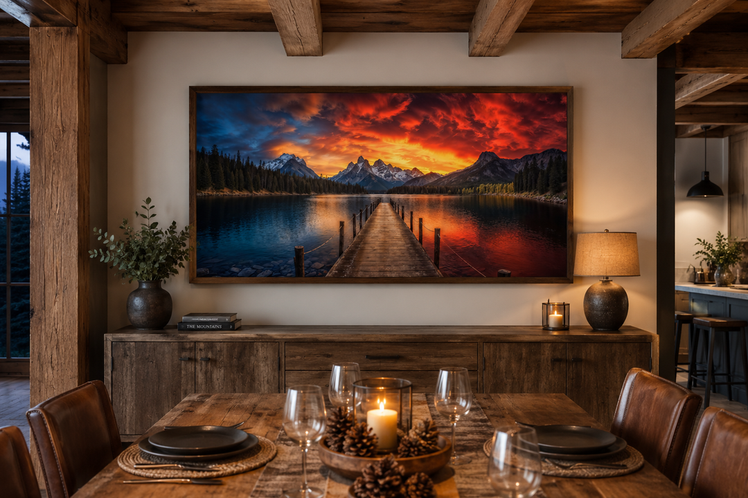 Framed canvas wall art of a mountain lake and fishing pier under a vibrant sunset in a rustic room.