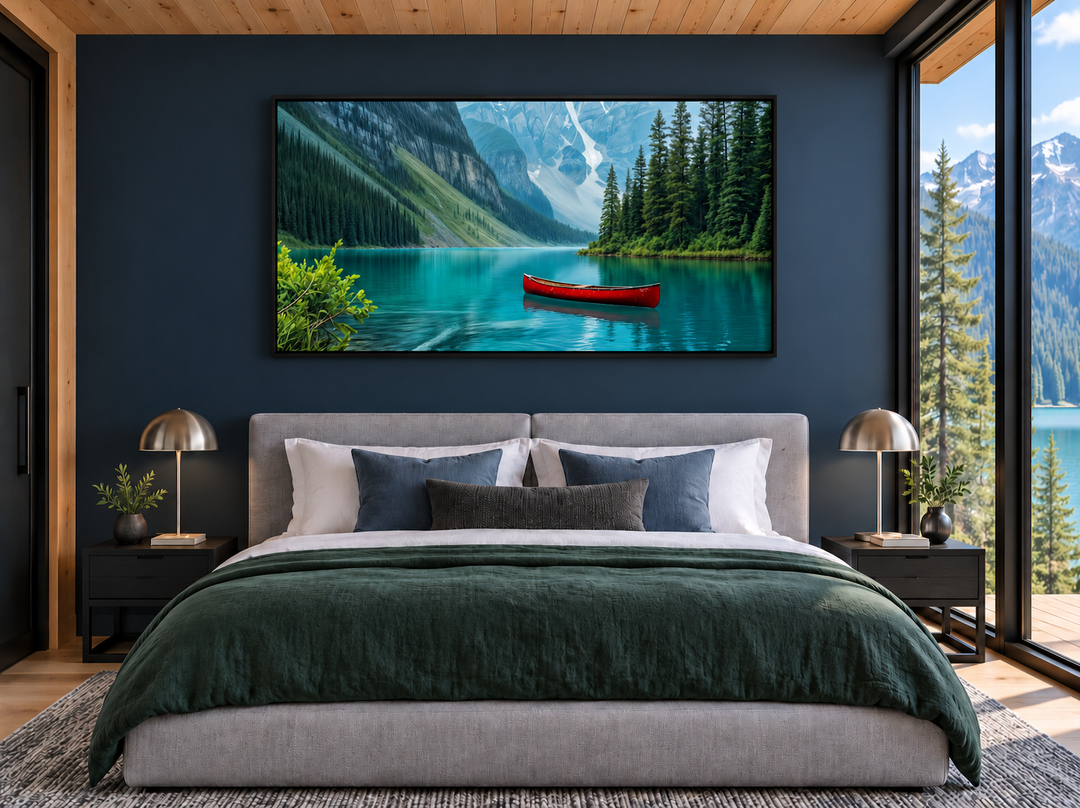 Framed canvas wall art of Lake Louise with a red canoe, hanging above a bed in a modern bedroom.