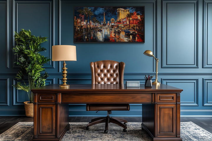 Las Vegas Strip At Night Framed Canvas Wall Art hanging in a dark blue office above a wooden desk.