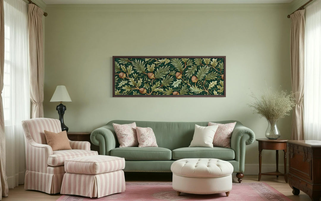 William Morris style horizontal wall art with green leaves and acorns above a green sofa.