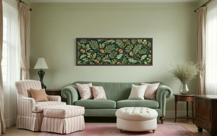 William Morris style horizontal wall art with green leaves and acorns above a green sofa.
