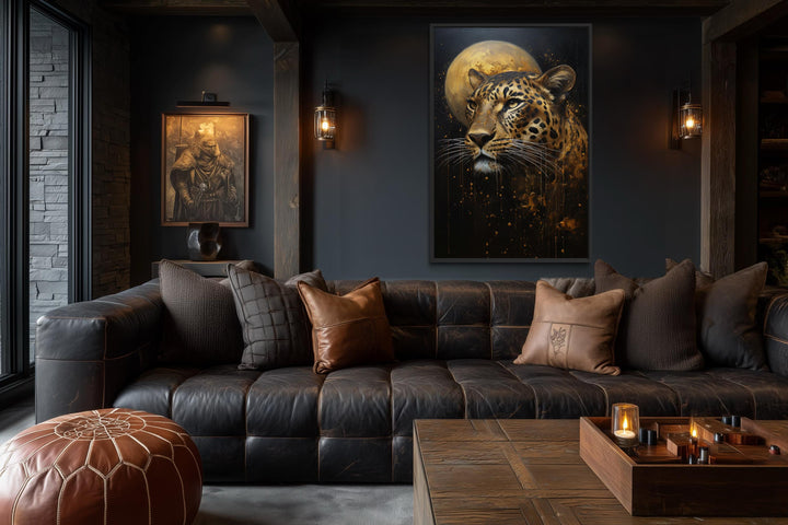 Moody leopard and moon canvas print displayed in a dark, modern living room with leather furniture.