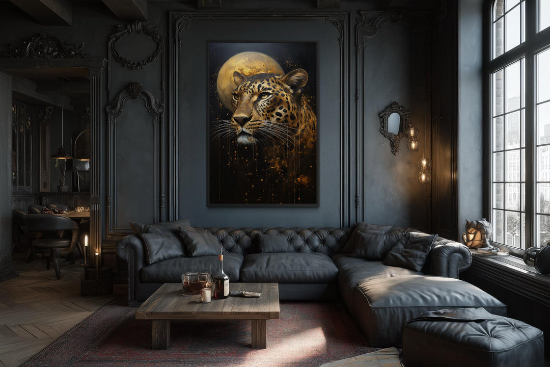 A moody leopard and moon canvas print hangs in a dark, luxurious living room with a leather sofa.