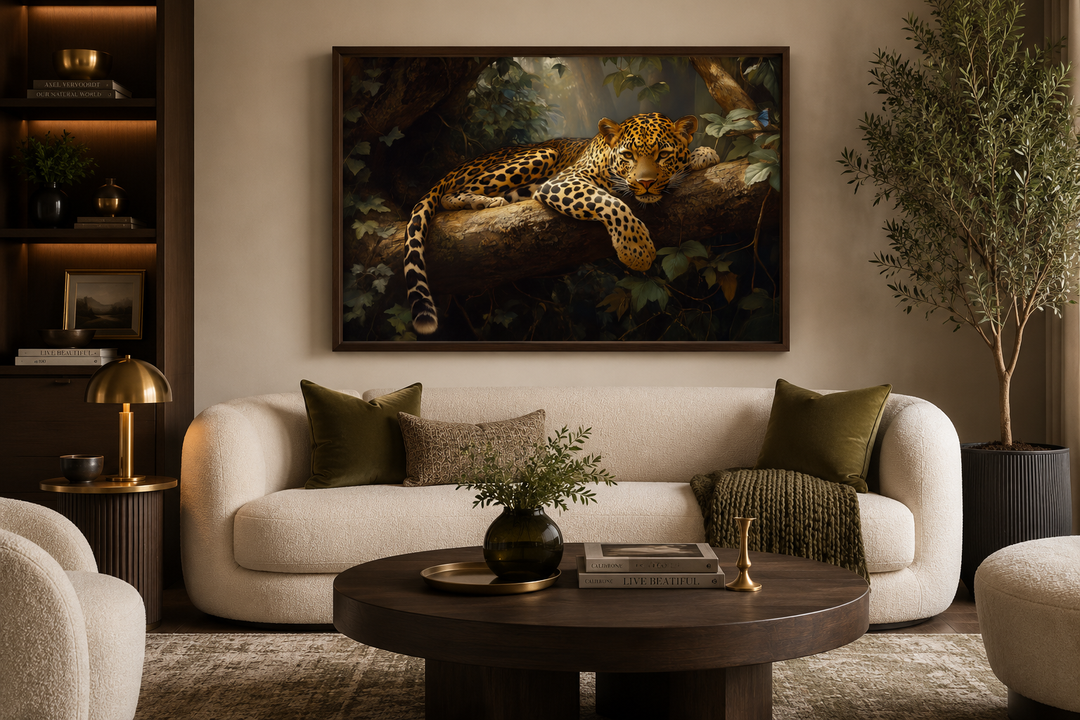 Framed canvas wall art of a leopard resting on a tree branch in a lush jungle above a white sofa.