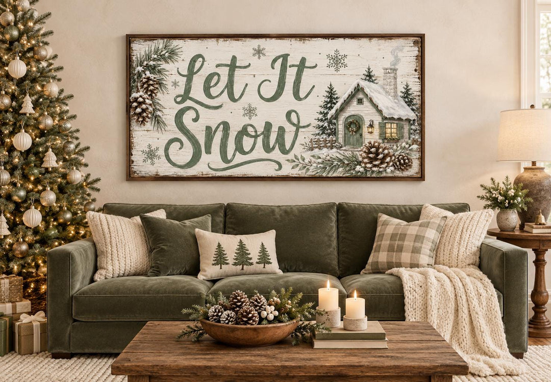 Let It Snow sage green script and snowy cottage framed canvas wall art above a green sofa.