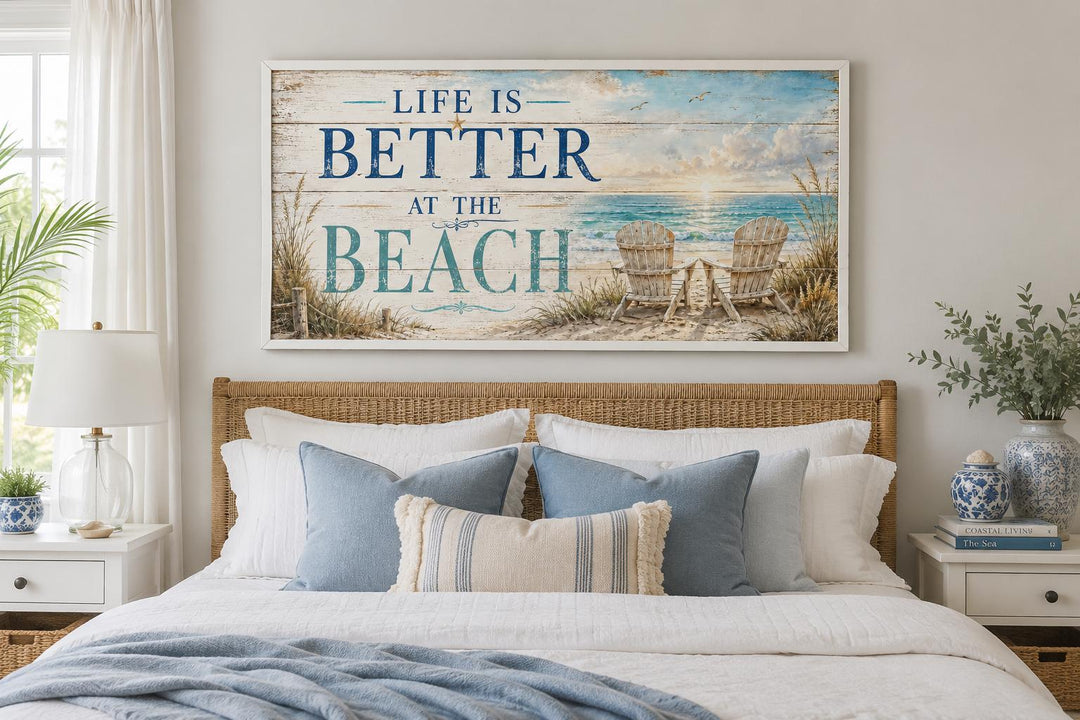 Life Is Better at the Beach canvas sign above a bed with blue pillows and a rattan headboard.