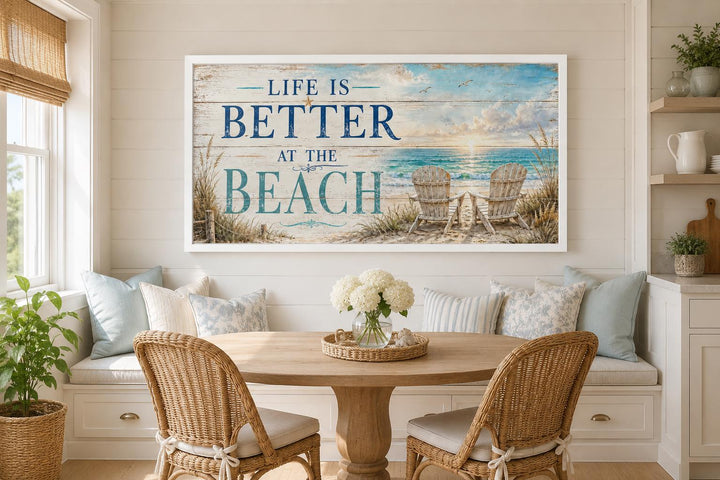 Life Is Better at the Beach canvas sign with an ocean view and beach chairs in a coastal dining nook.