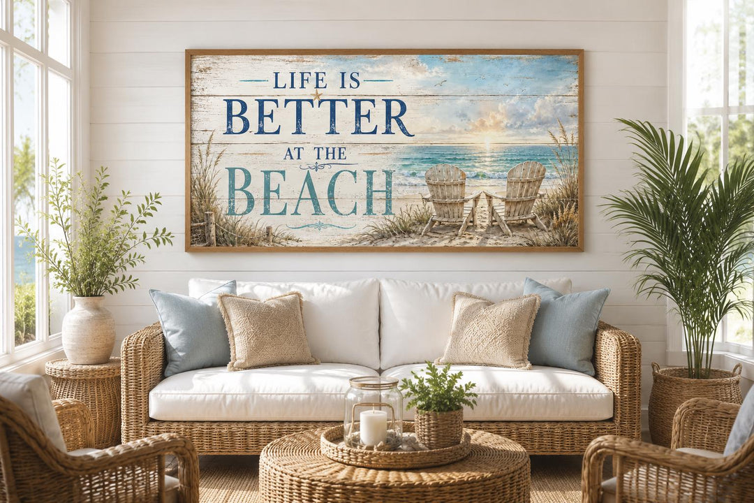 Life Is Better at the Beach coastal wall art hanging above a white sofa with rattan furniture.