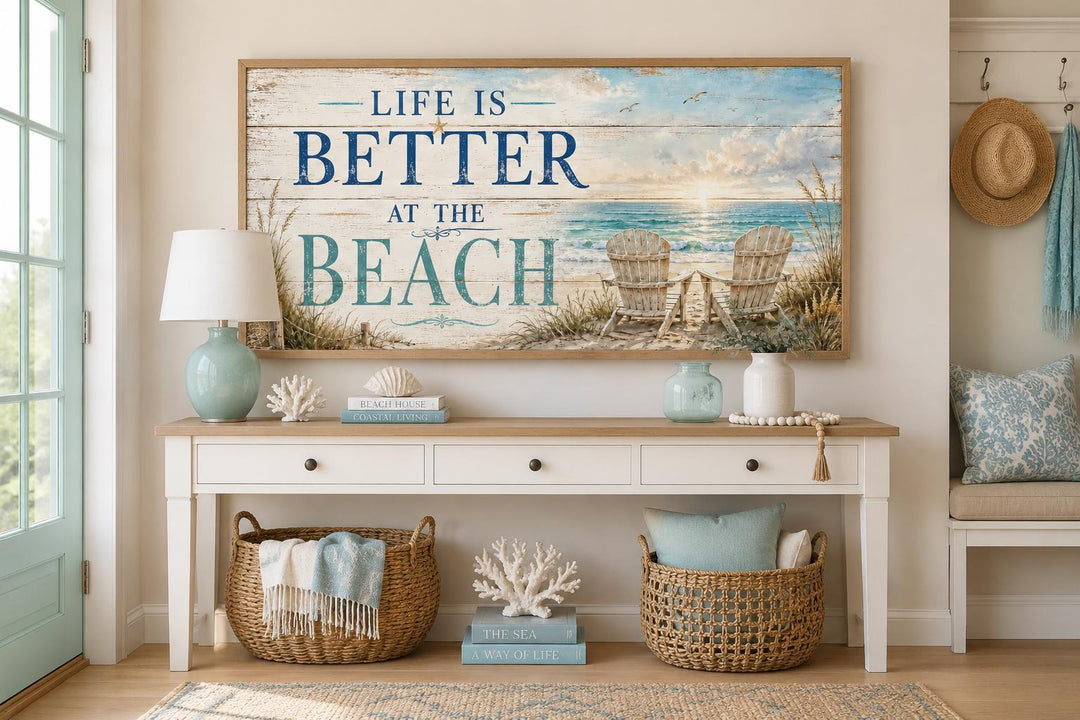 Life Is Better at the Beach coastal canvas sign with ocean view and beach chairs above a console.