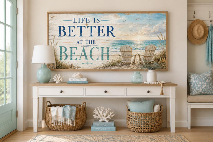 Life Is Better at the Beach coastal canvas sign with ocean view and beach chairs above a console.