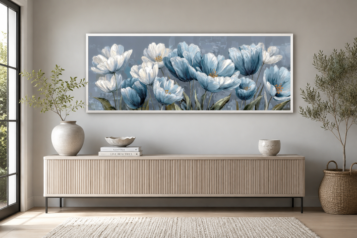 Light blue abstract floral wall art in a white frame above a modern wooden sideboard.
