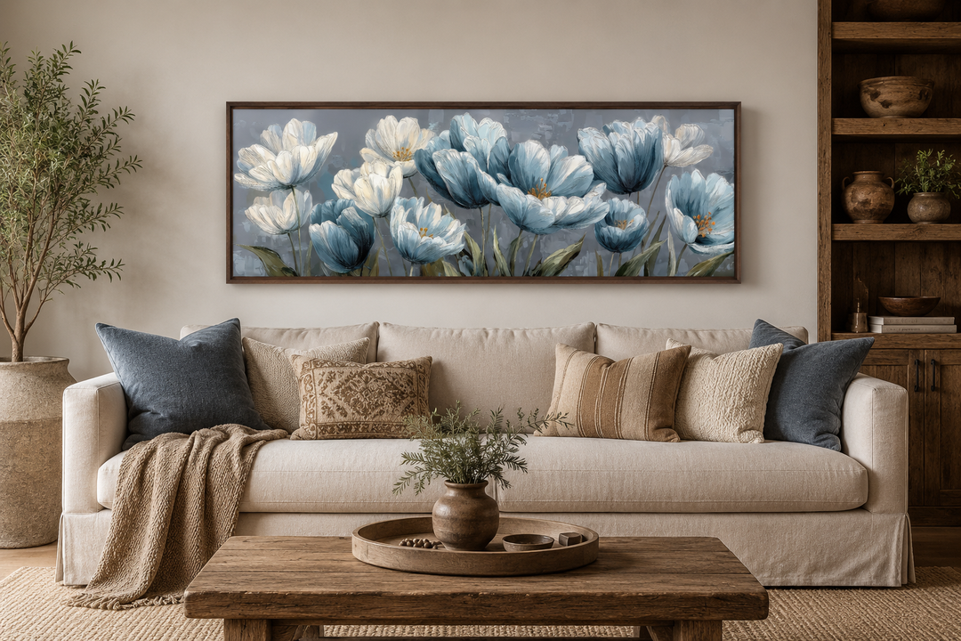 Light blue abstract flowers long horizontal wall art in a dark wood frame above a beige sofa.