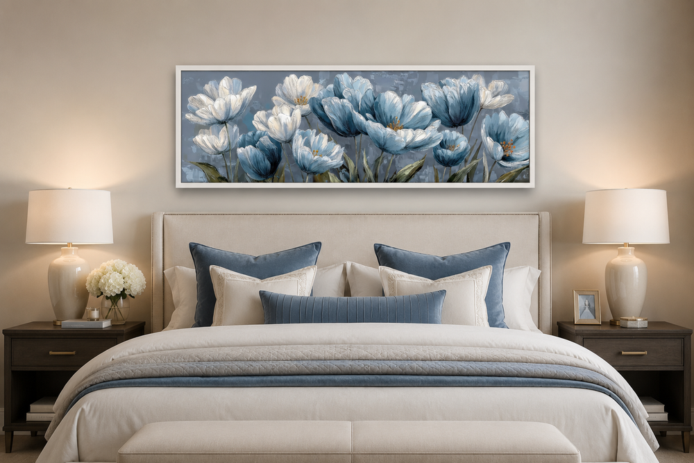 Light blue abstract floral horizontal wall art hanging above a bed with blue and white pillows.