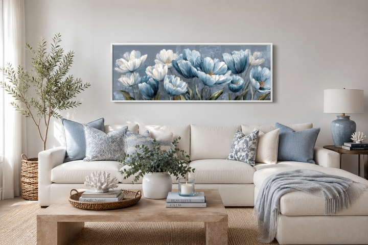 Light blue abstract flowers long horizontal wall art hanging above a white sectional sofa.