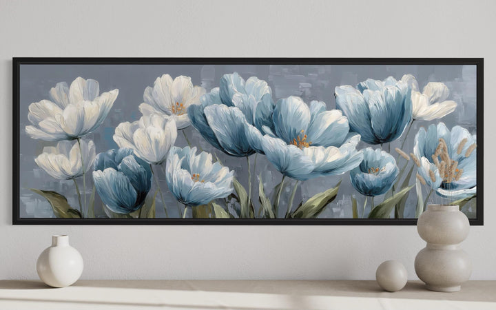 Long horizontal wall art of light blue and white abstract flowers in a black frame above a console.