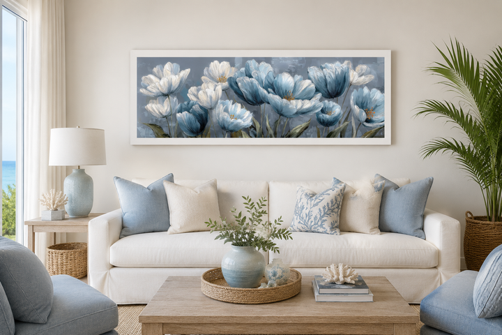 Light blue abstract floral wall art in a white frame above a white sofa with blue pillows.