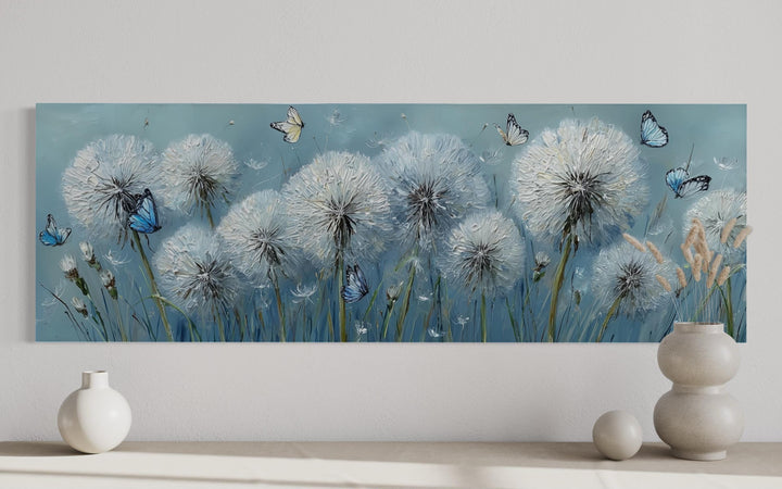 Horizontal framed canvas wall art featuring textured white dandelions and blue butterflies.