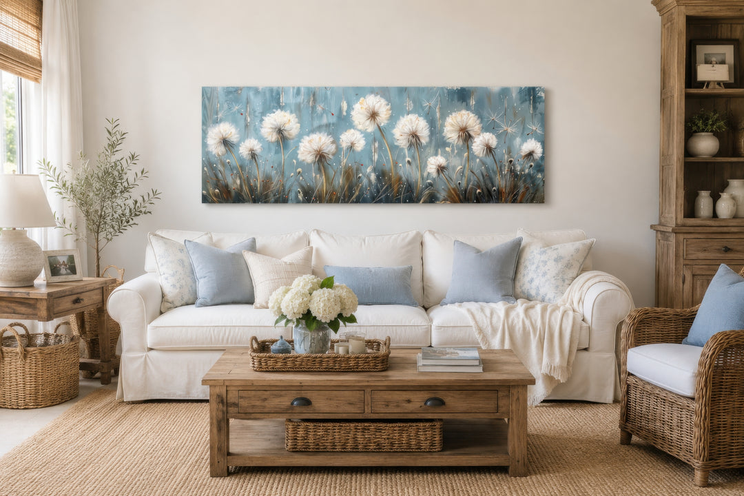 Horizontal framed canvas wall art featuring light blue dandelions and butterflies over a white sofa.