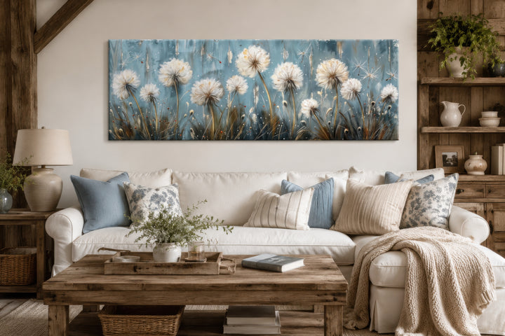 Horizontal framed canvas wall art featuring light blue dandelions and butterflies over a sofa.