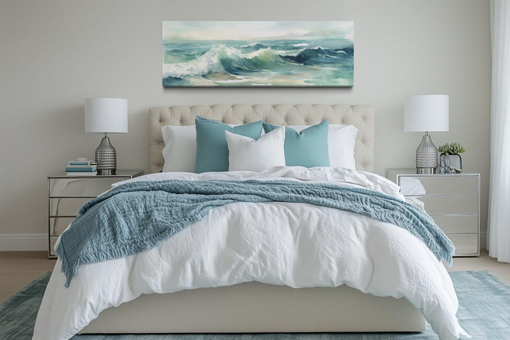 Light green ocean waves minimalist horizontal wall art hanging above a bed in a coastal bedroom.