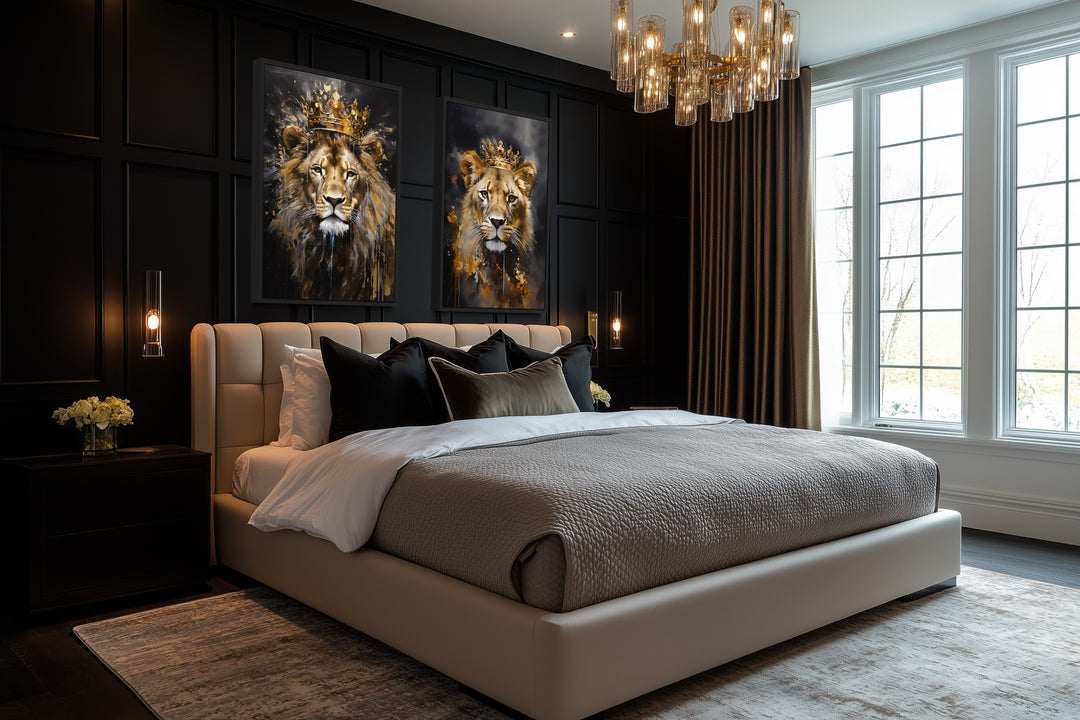Two framed canvas prints of a lion and lioness wearing gold crowns on a black paneled bedroom wall.