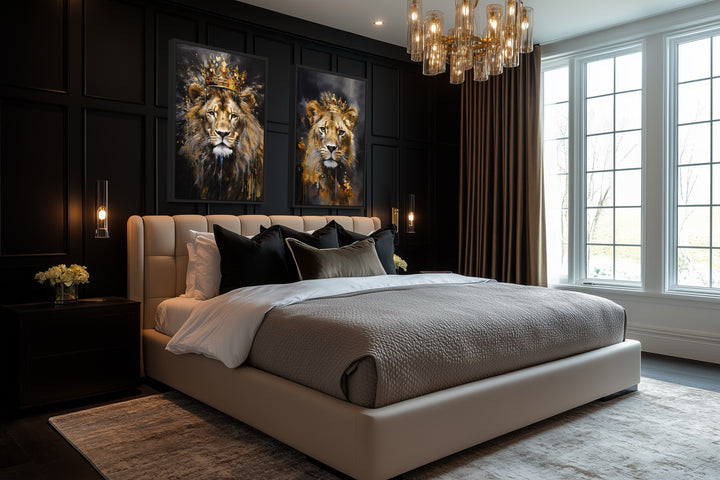 Two framed canvas prints of a lion and lioness wearing gold crowns on a black paneled bedroom wall.