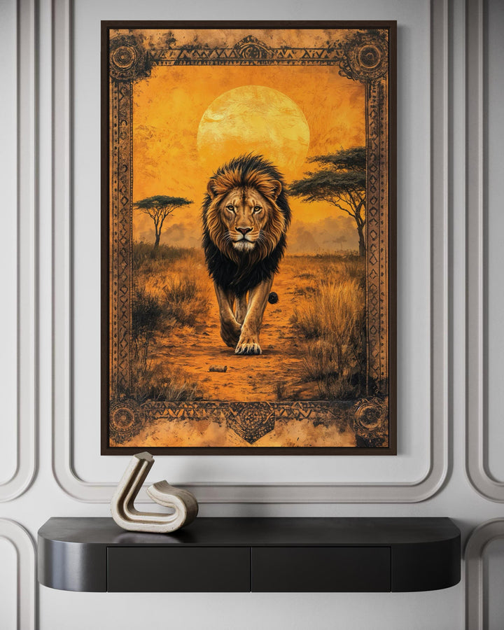 Framed canvas wall art of a lion walking through the African savanna at sunset with a golden moon.