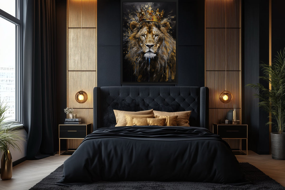 Framed canvas wall art of a lion wearing a gold crown, centered above a black tufted bed.