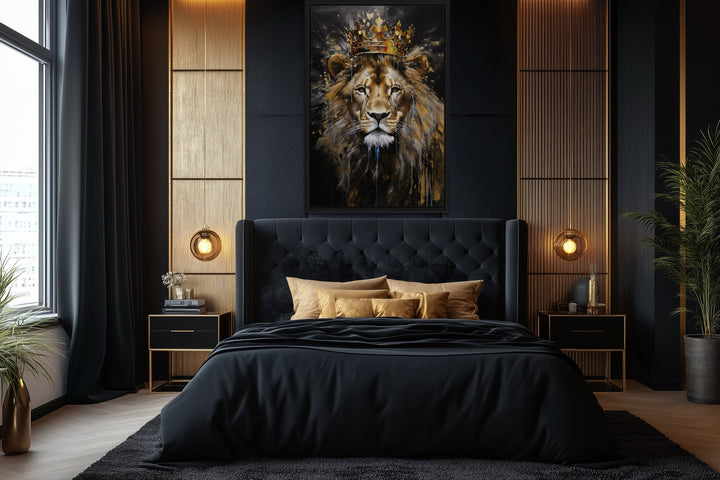 Framed canvas wall art of a lion wearing a gold crown, centered above a black tufted bed.