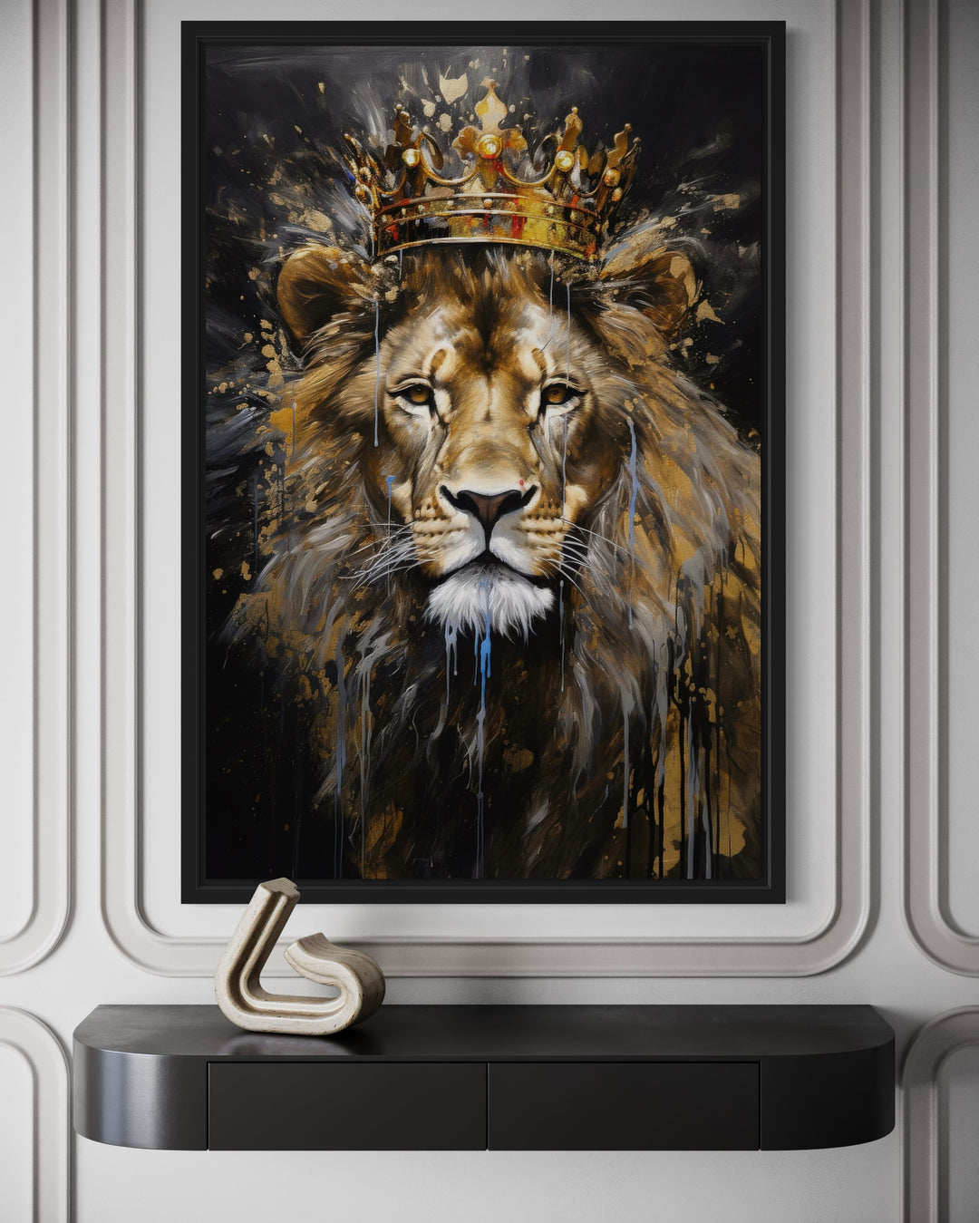 Framed canvas wall art of a majestic lion wearing a gold crown, hanging above a black console table.