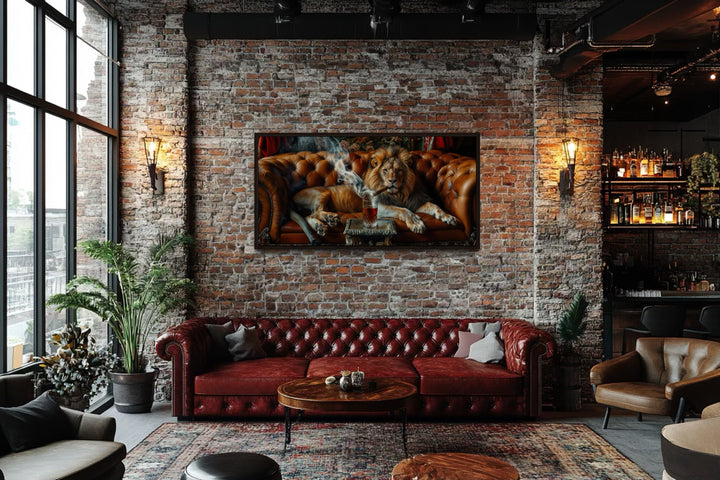 Lion on a couch smoking a cigar framed canvas print hanging on a brick wall in a man cave.