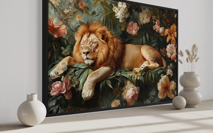 Framed canvas wall art of a lion sleeping among lush jungle flowers and greenery.